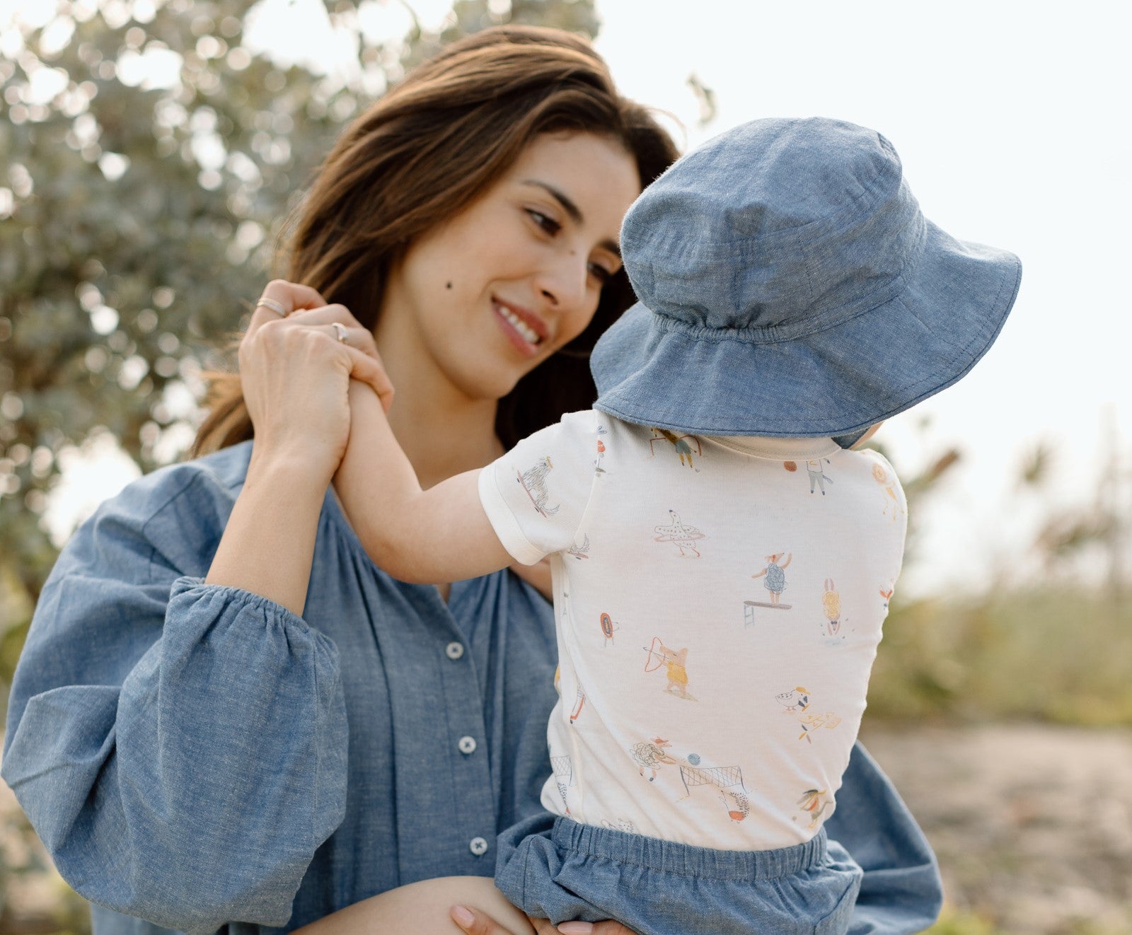 A mom wearing Chambray holds her baby.