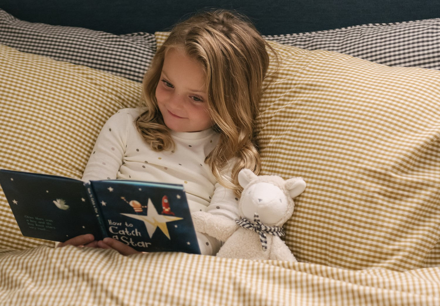 Toddler sitting in bed reading a book