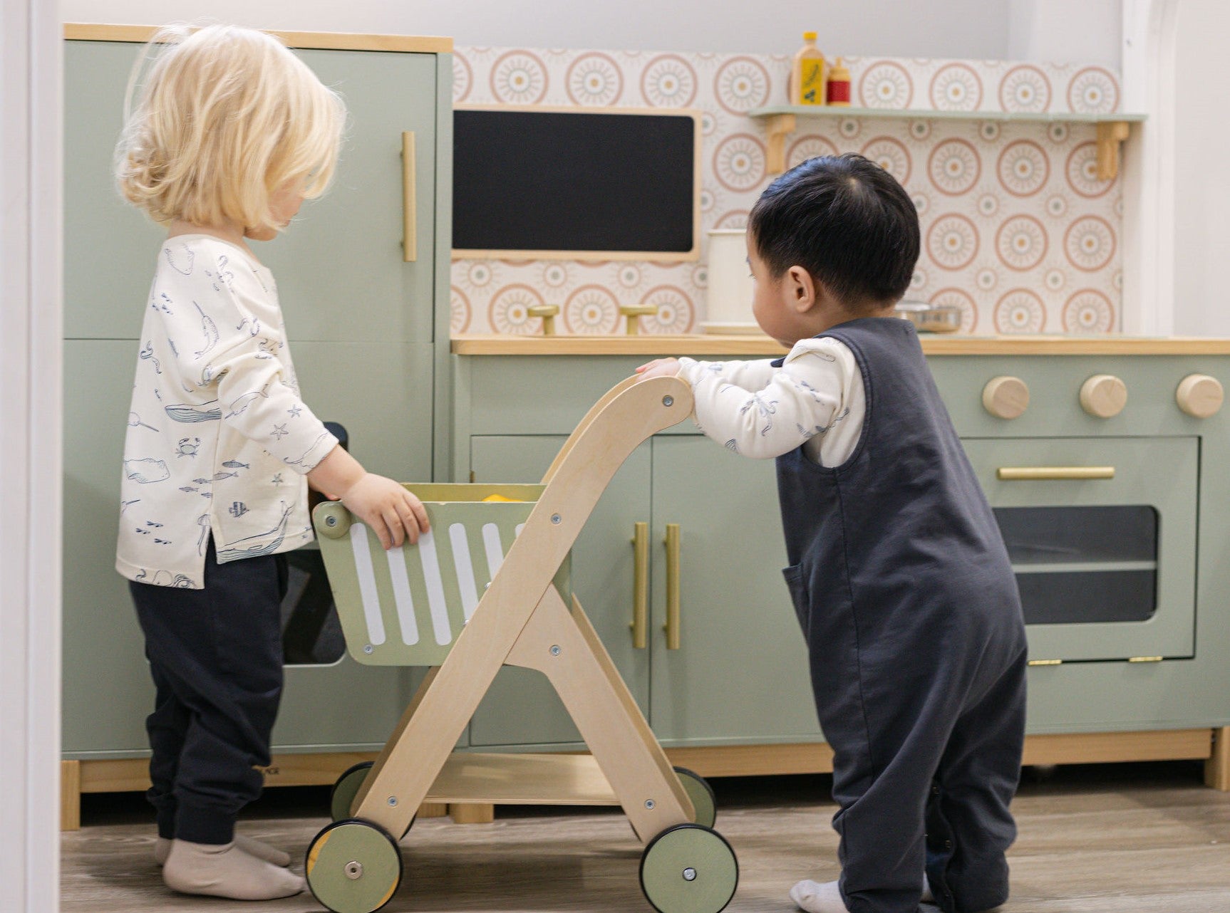 Image of two toddlers playing in children's kitchen