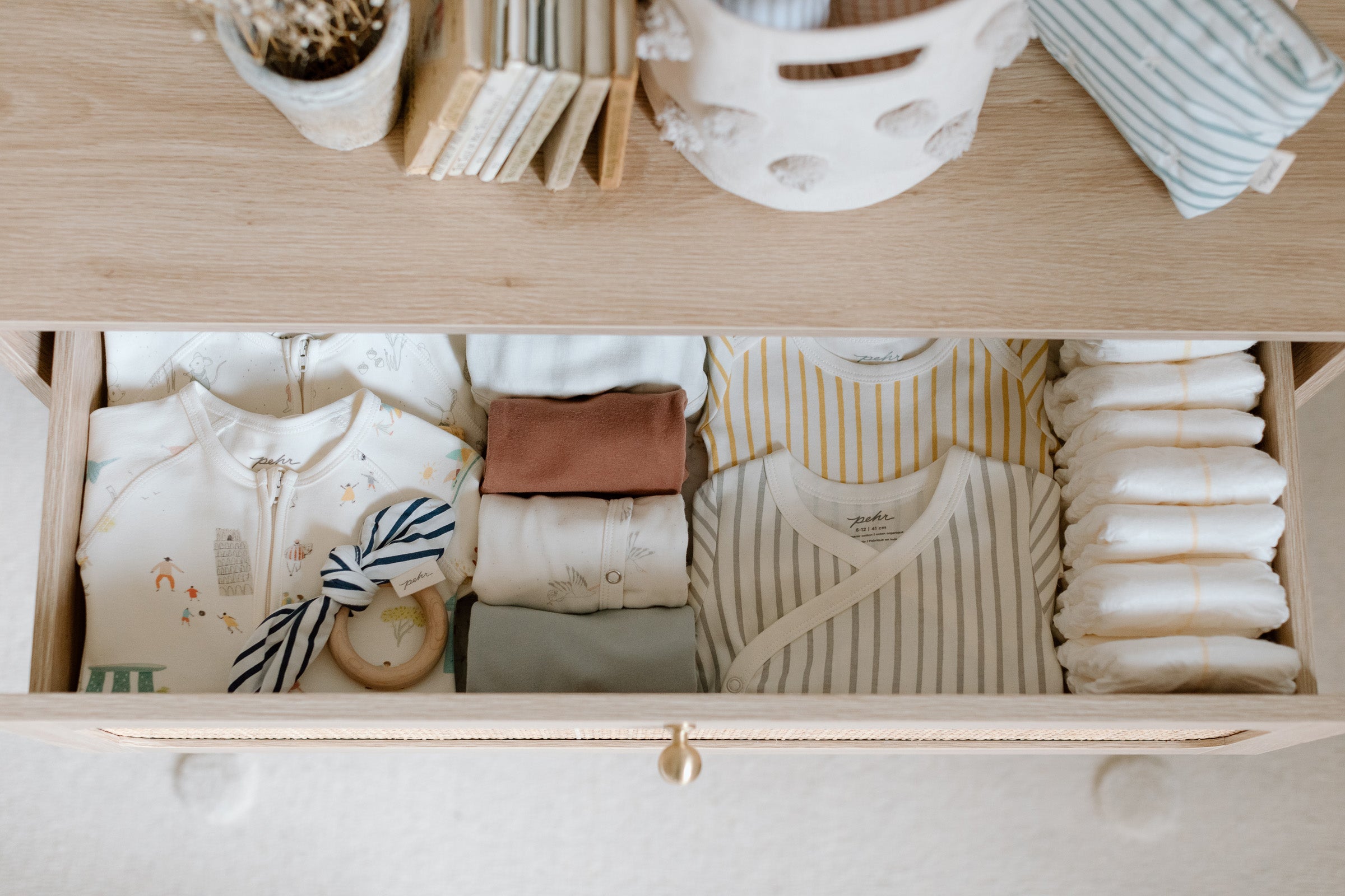 Overhead shot of dresser drawer filled with diapers and baby clothes