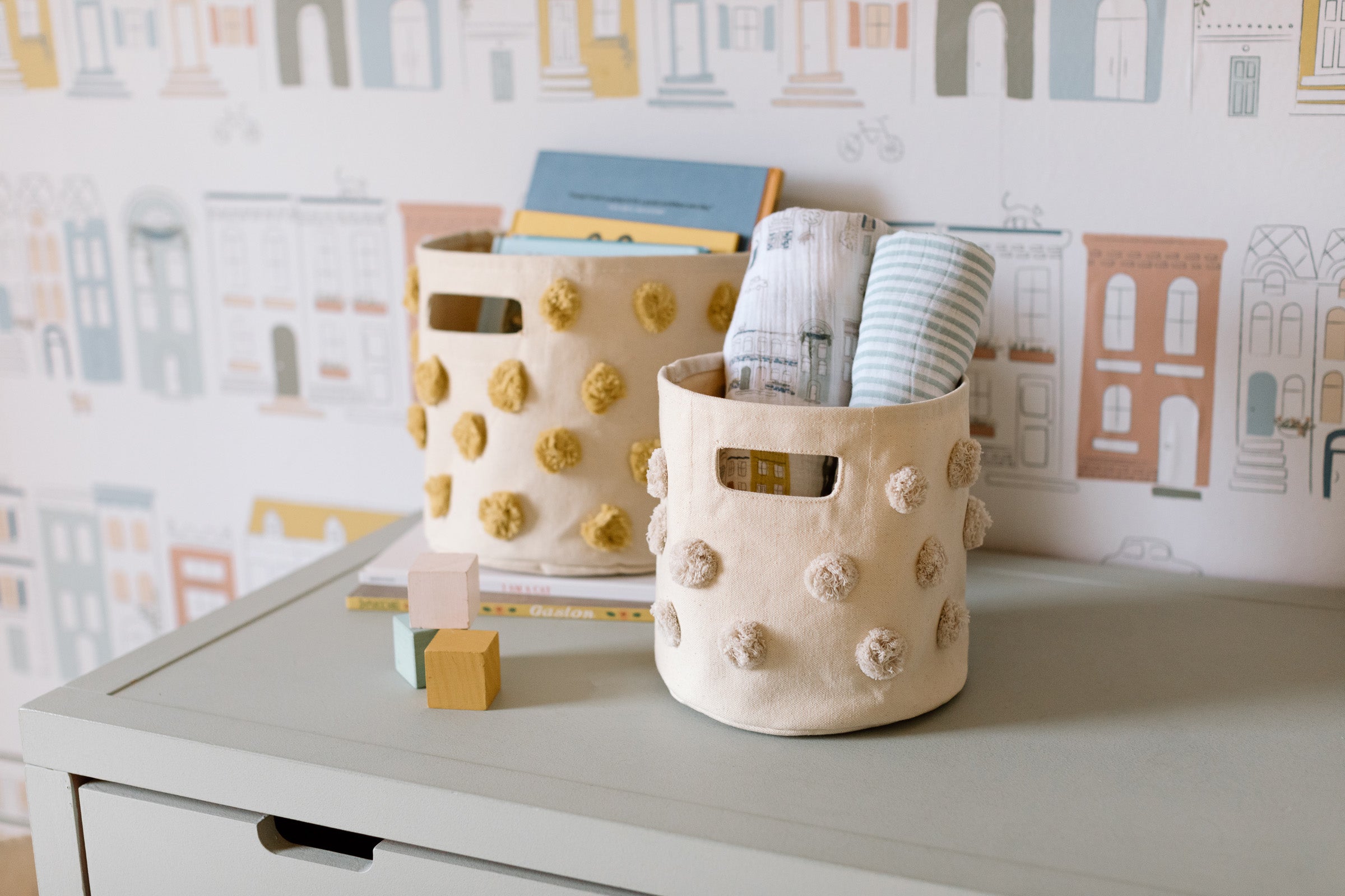 An image of two pom pom baskets on a shelving unit.