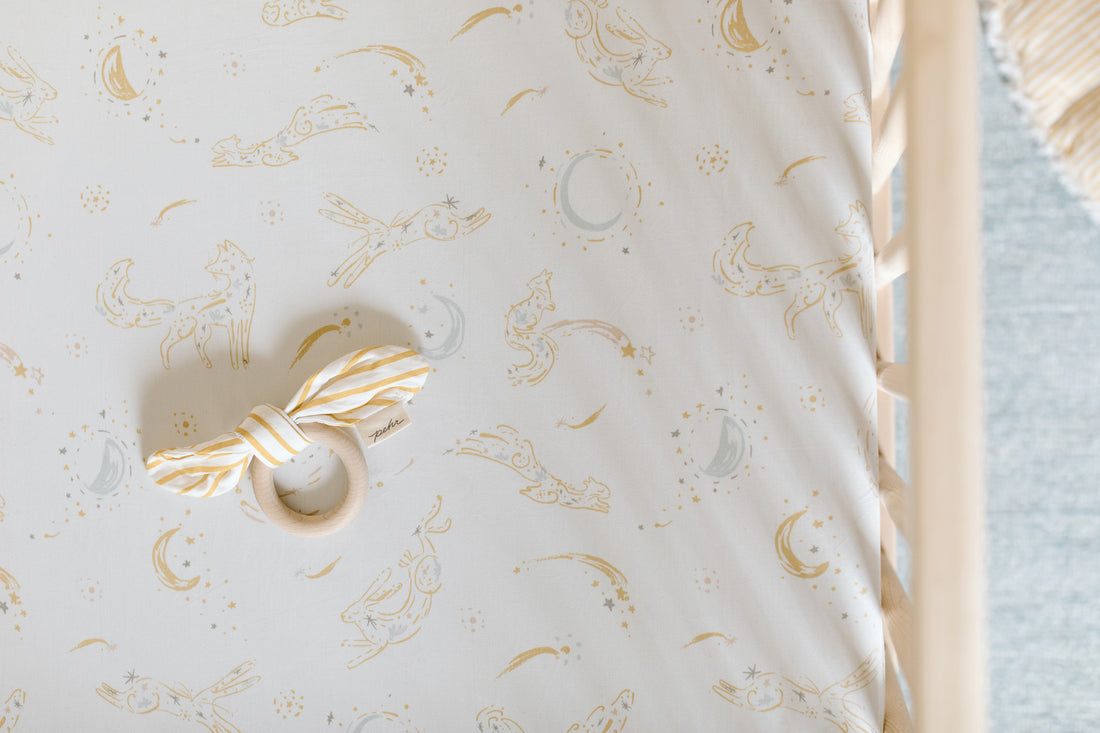 Overhead image of crib with Pehr Crib Sheet and Teether