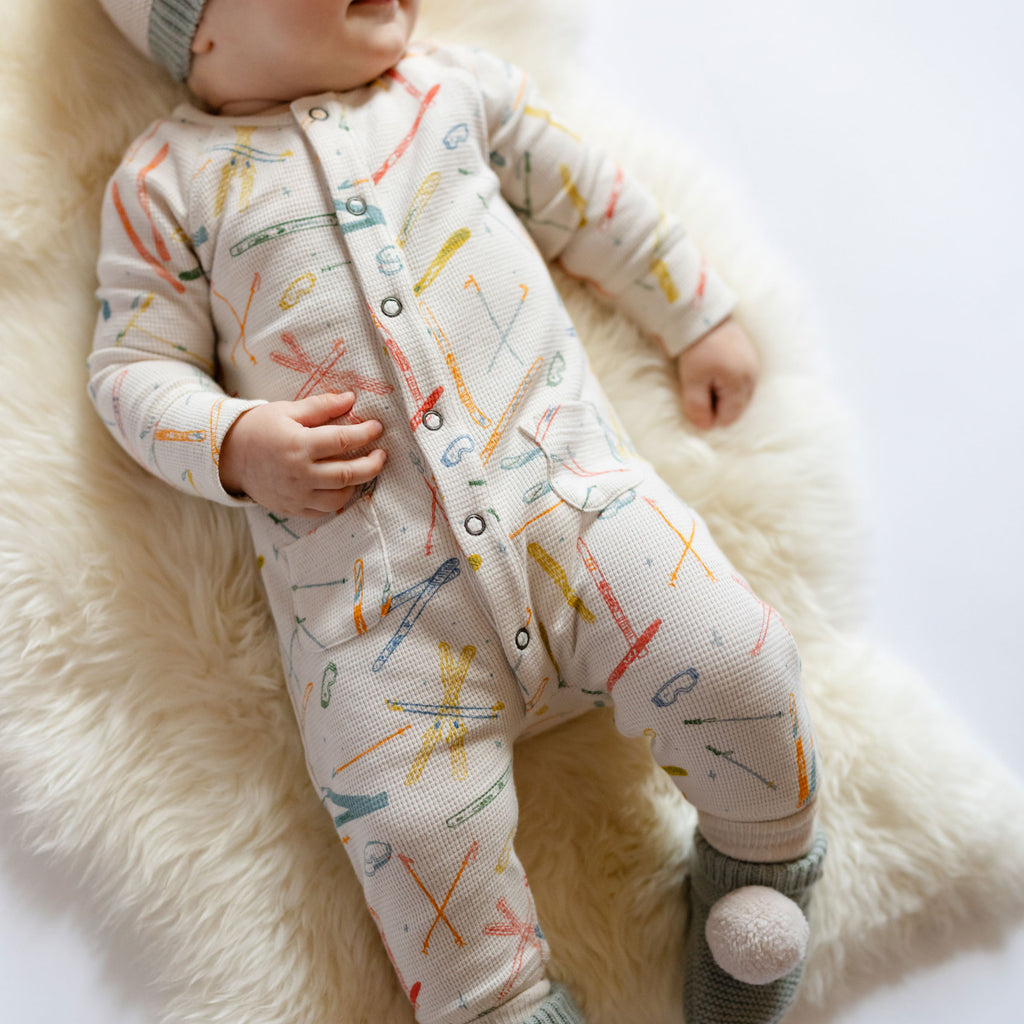 Petit Ski Raglan Romper - Apres- Long Sleeve and Legs- On Baby- White with Colorful Ski print