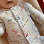 Petit Ski Raglan Romper - Apres- Up Close On Baby- White with Colorful Ski print- Snap Buttons