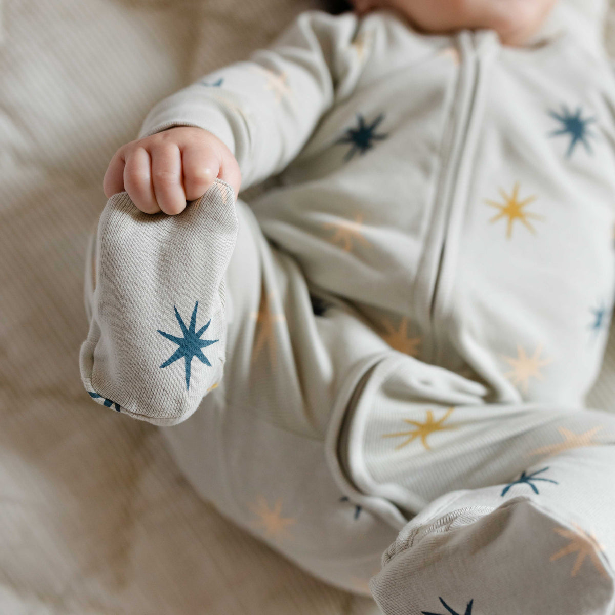 Ribbed Baby Sleeper - North Star- Up Close On Baby With Feet In The Air- Green With Star Print