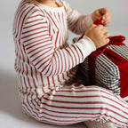 Ribbed Toddler Pajama - Stripes Away Berry- Close Up Stripes on Toddler- Holding Present