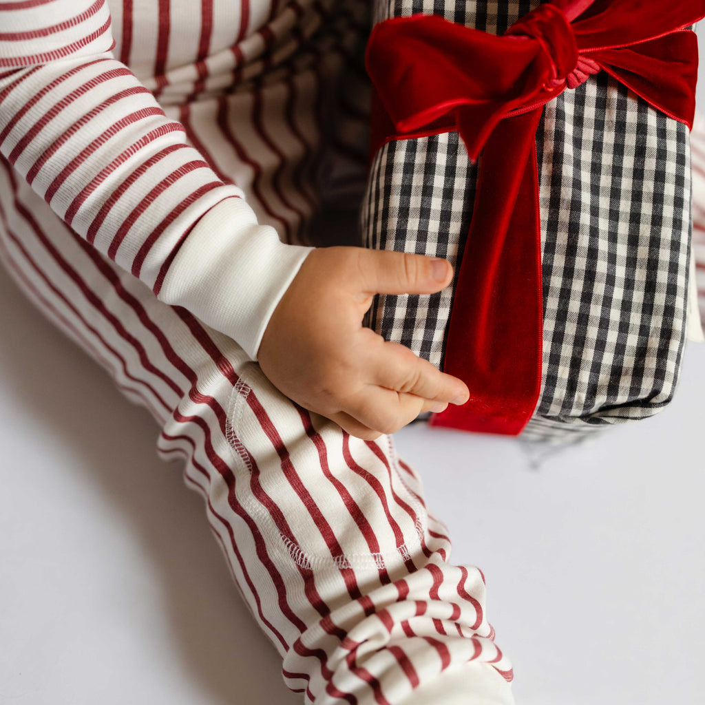 Ribbed Toddler Pajama - Stripes Away Berry- Close Up Stripes on Toddler- Holding Present