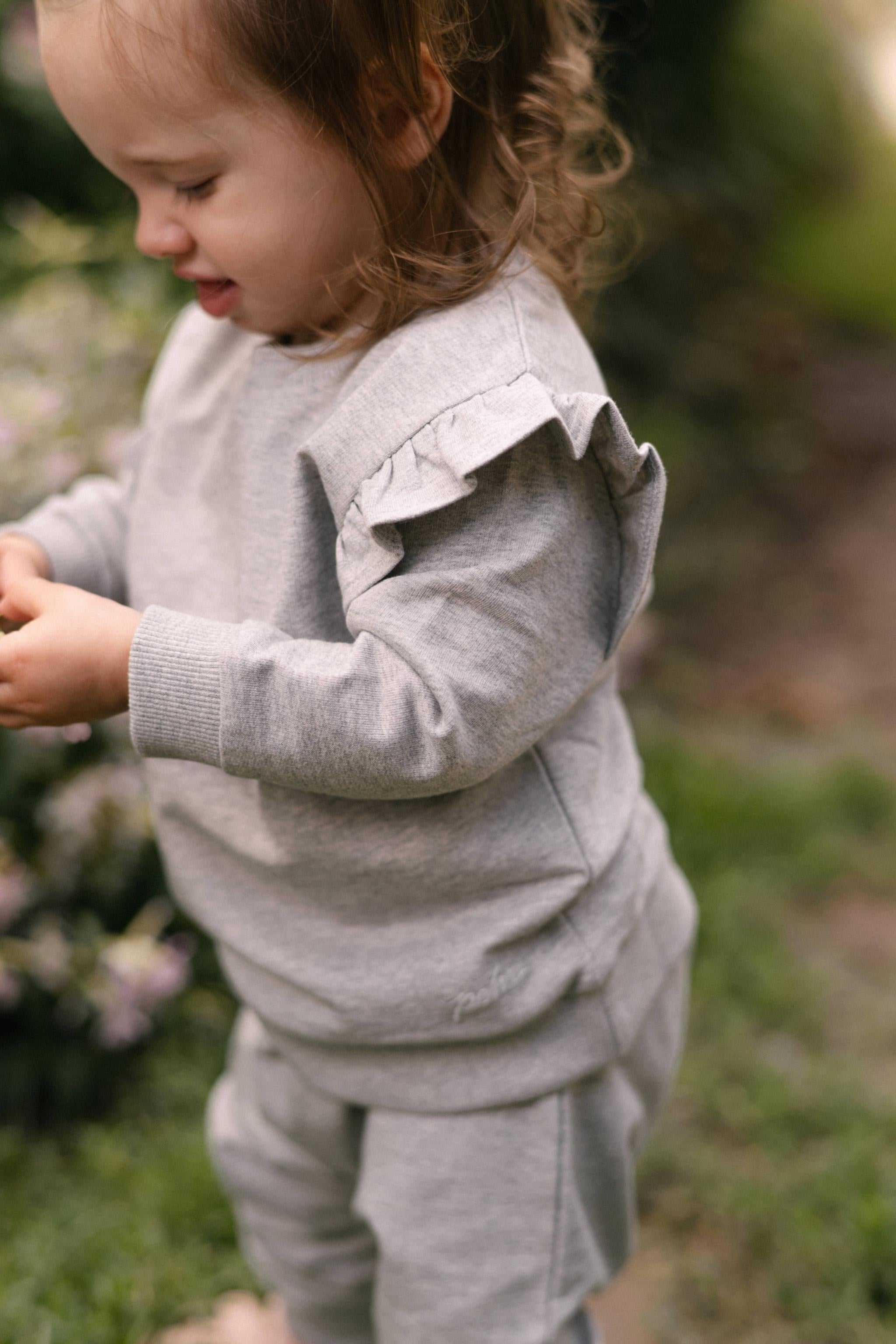 French Terry Toddler Ruffle Sweatshirt - Heather Grey- Side- Up Close Ruffle - On Model
