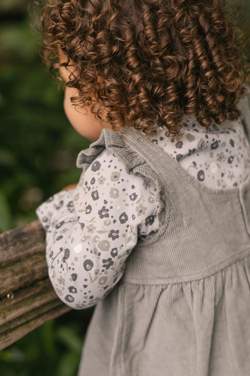 corduroy pinafore dress sage in greens pattern up close on model