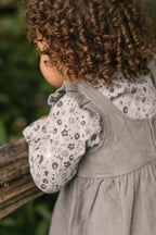 corduroy pinafore dress sage in greens pattern up close on model