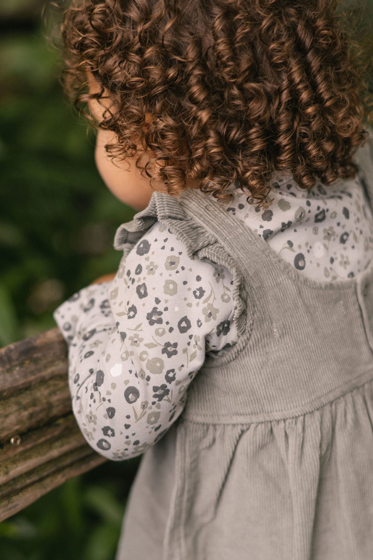 corduroy pinafore dress sage in greens pattern up close on model